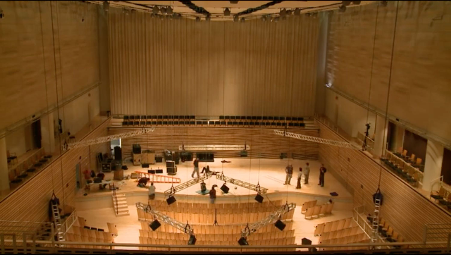 An aerial view of the concert hall as a crew work diligently on stage. 
