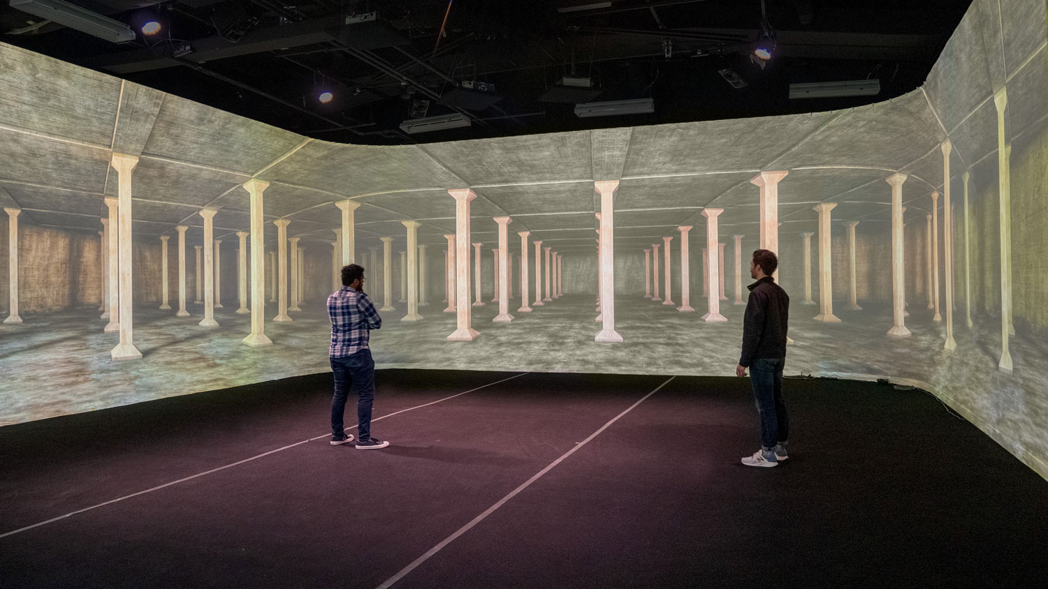 two men standing in a 360-degree immersive screen