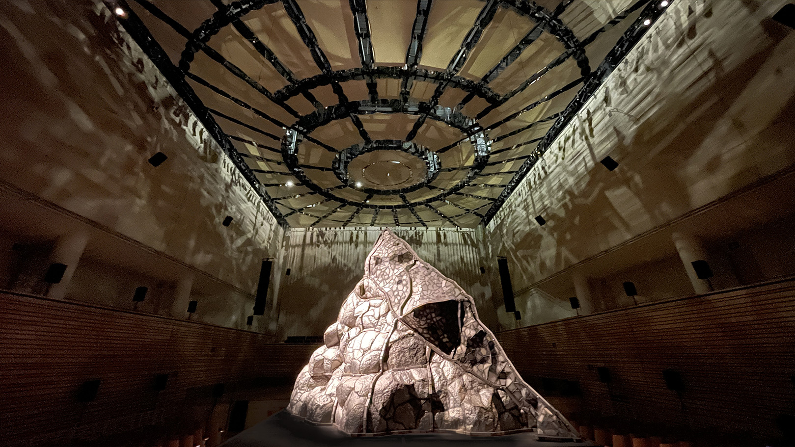 a steel volcano sits in the middle of the concert hall on a platform