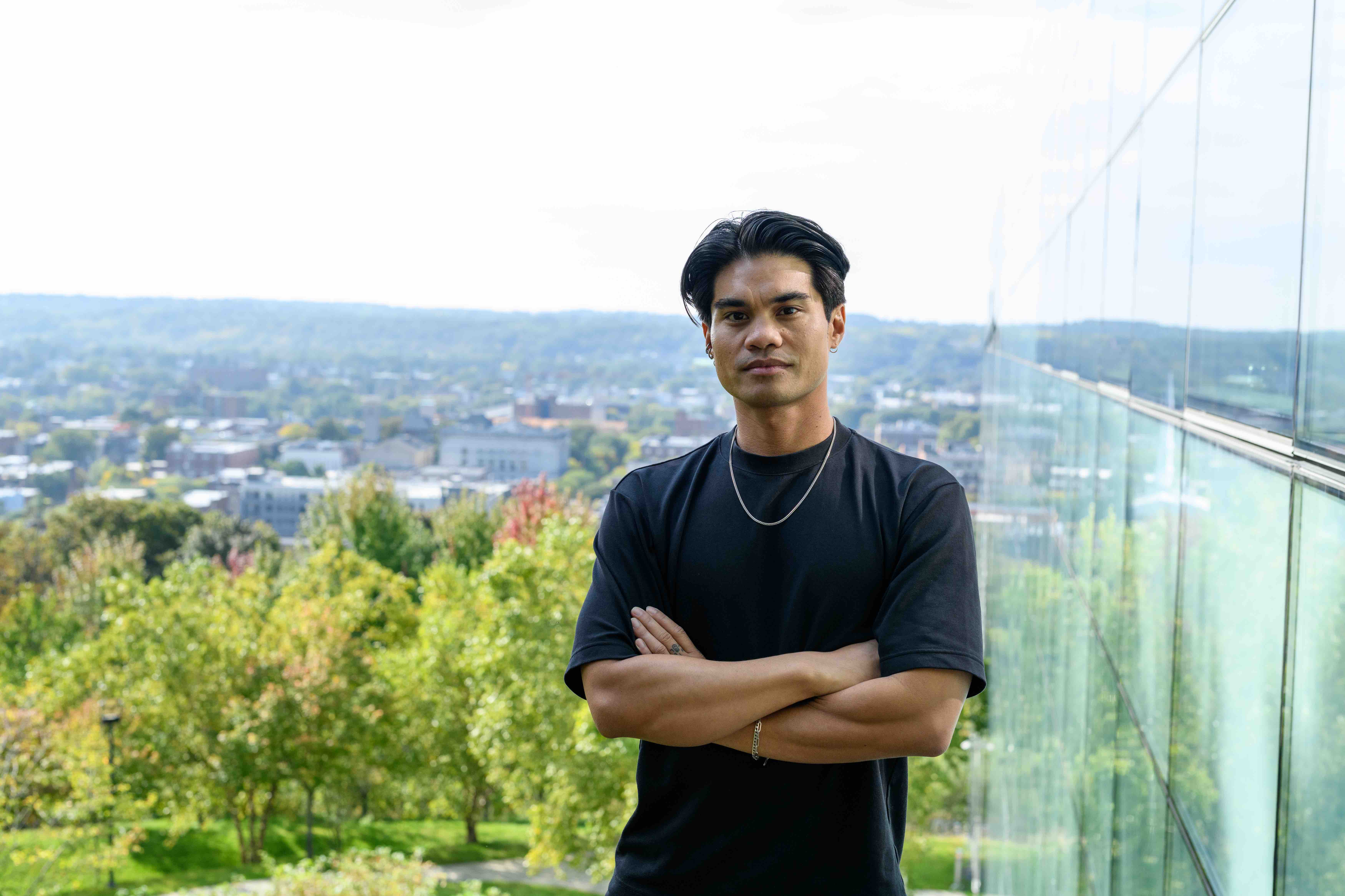 Filipino male in black standing on a hill overlooking Troy, New York