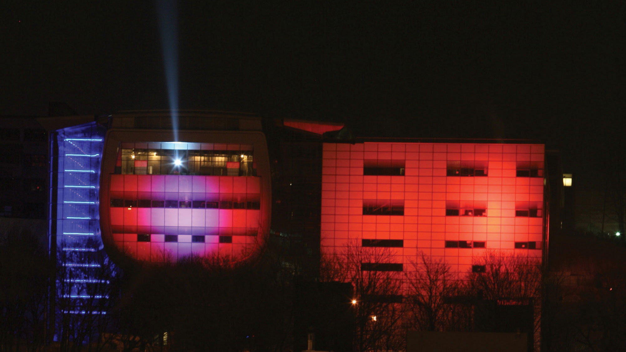The exterior of EMPAC lit with red light at night. 