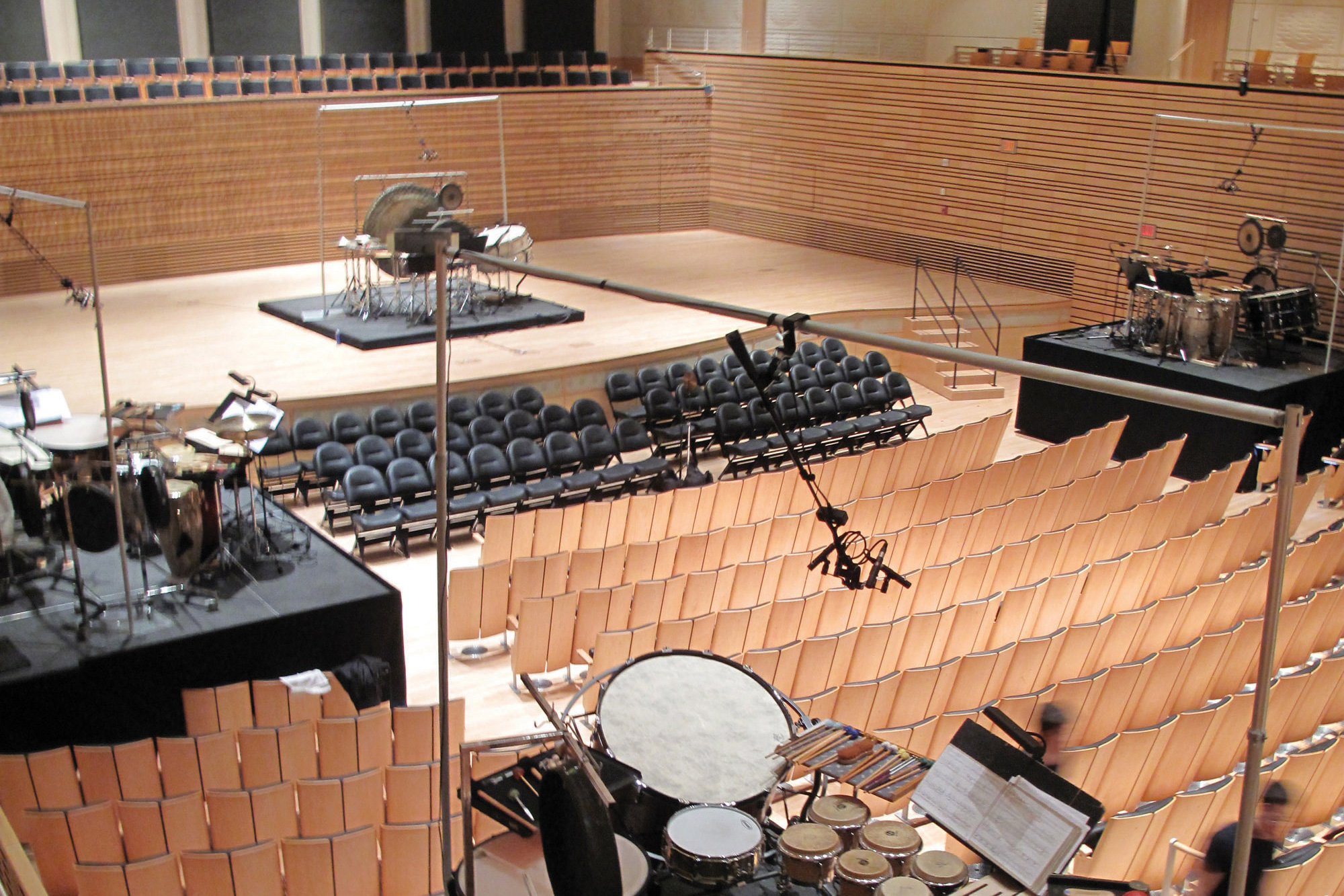 multiple drum sets circularly arranged in the empty concert hall. 