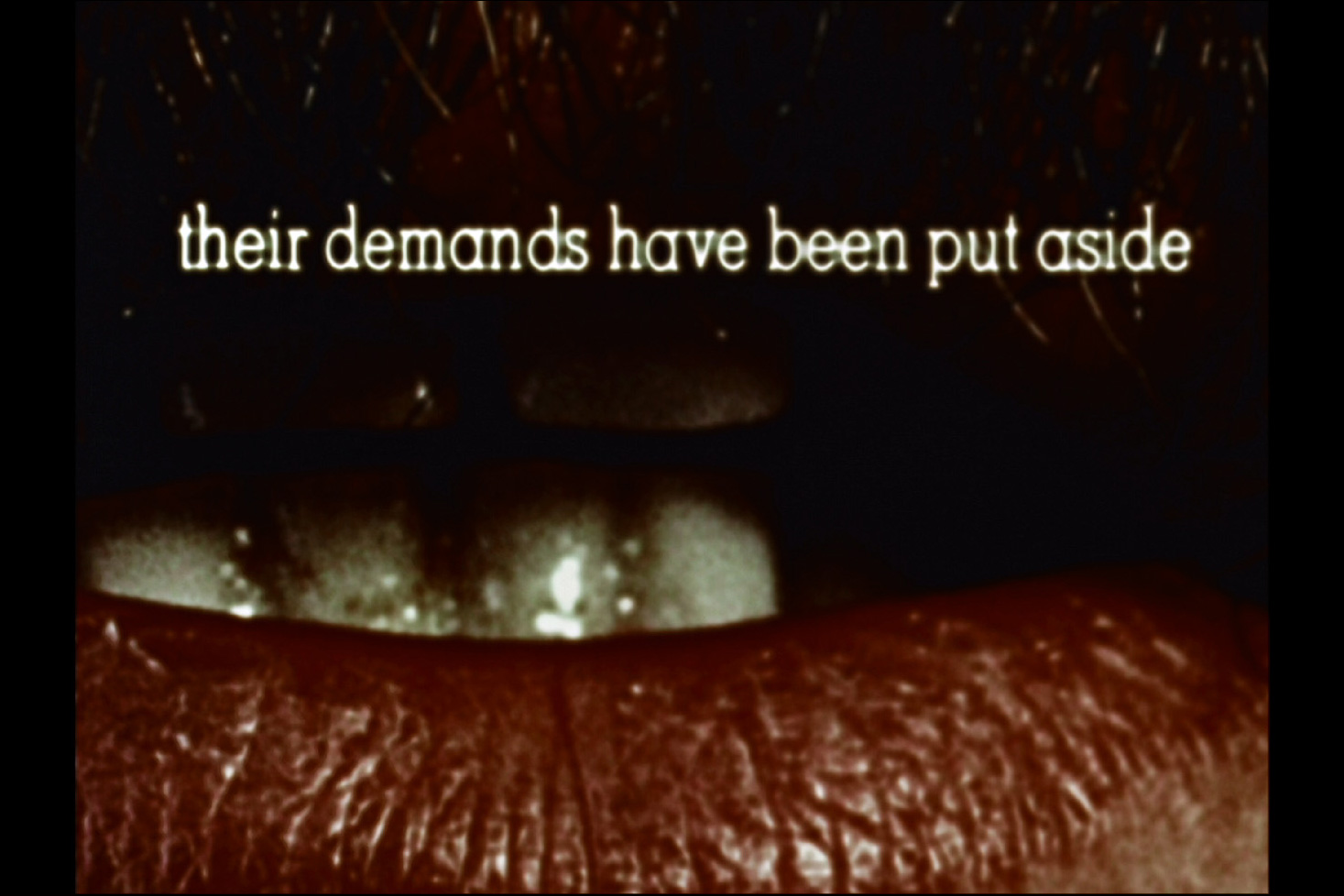 a tight shot of a mouth with text above it reading "their demands have been put aside" 