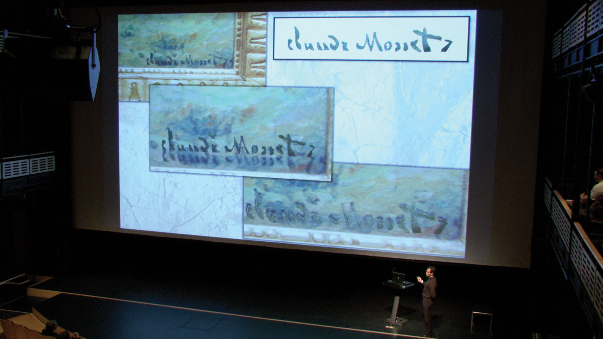 A large screen projecting four images of Claude Monet's signature. 