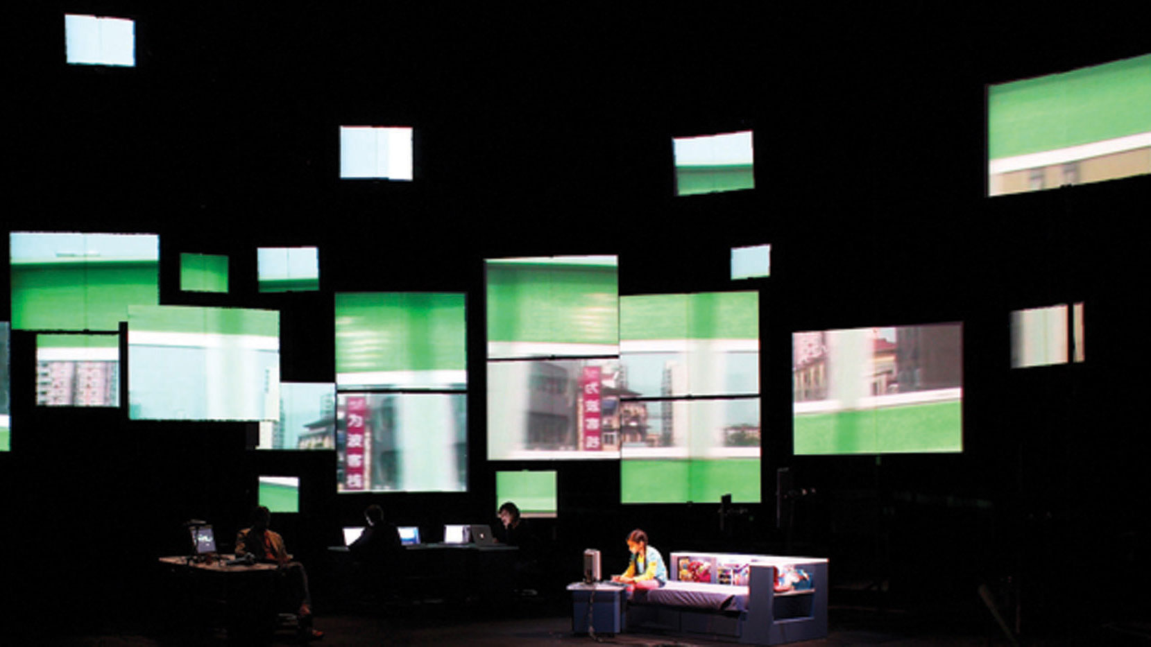 Multiple screens floating on a black wall. A little girl sitting on a bed playing the computer is in the foreground. 