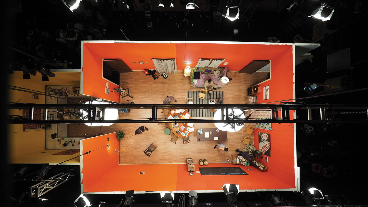 An aerial shot of an orange apartment film set, set up on a black box studio. 