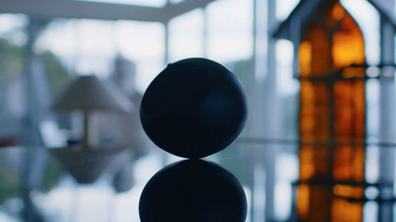 A round object on a reflective table in a naturally lit out pf focus room. 