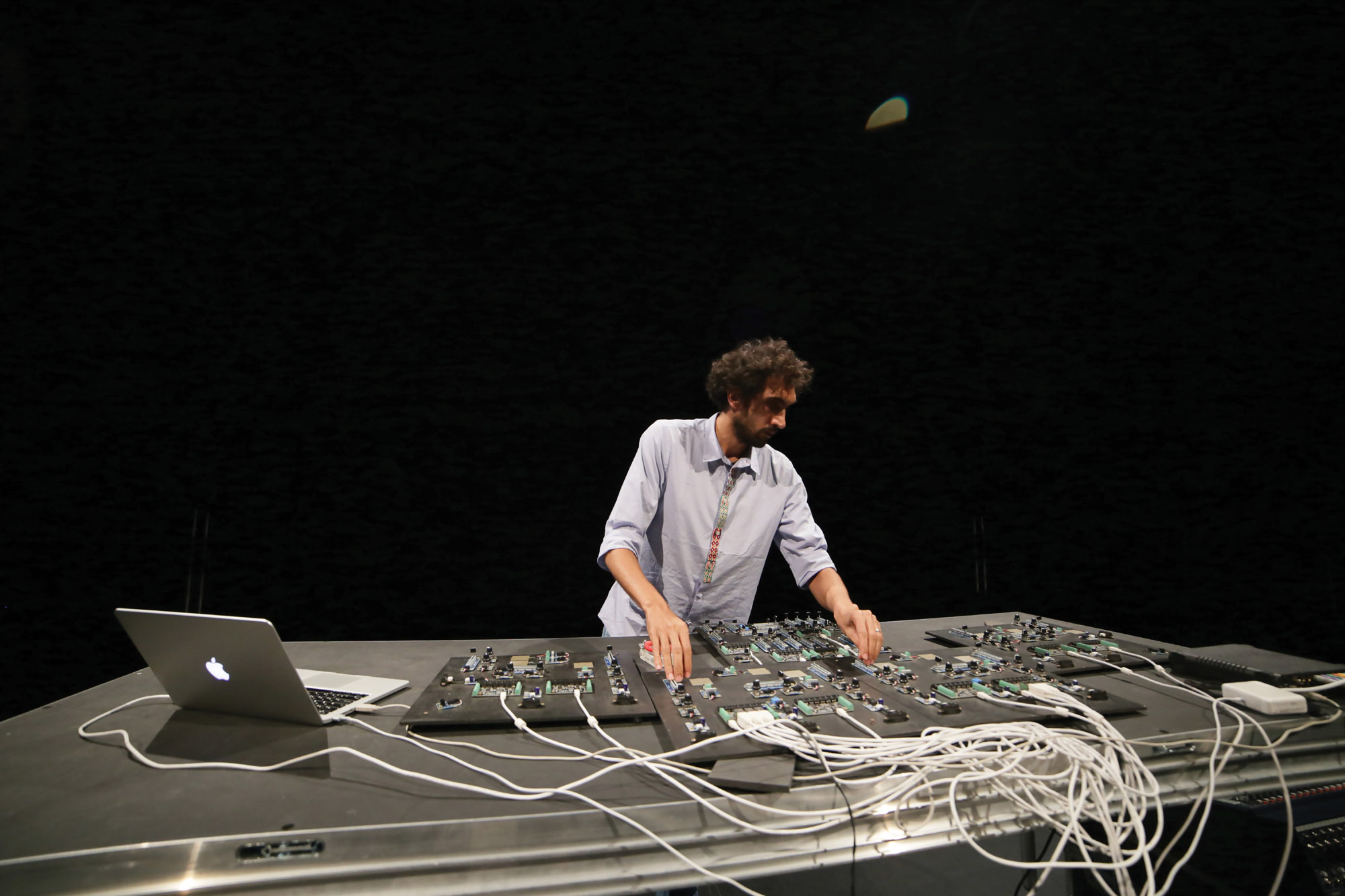 Tarek Atoui standing in front of a sound board. 