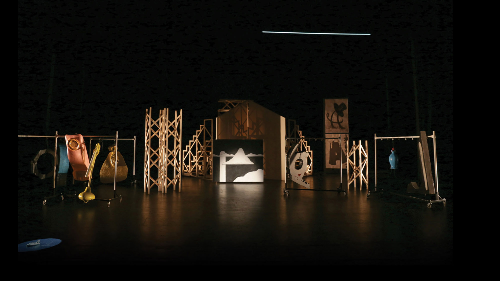 Various wood scaffolding and set pieces on a dark stage. 