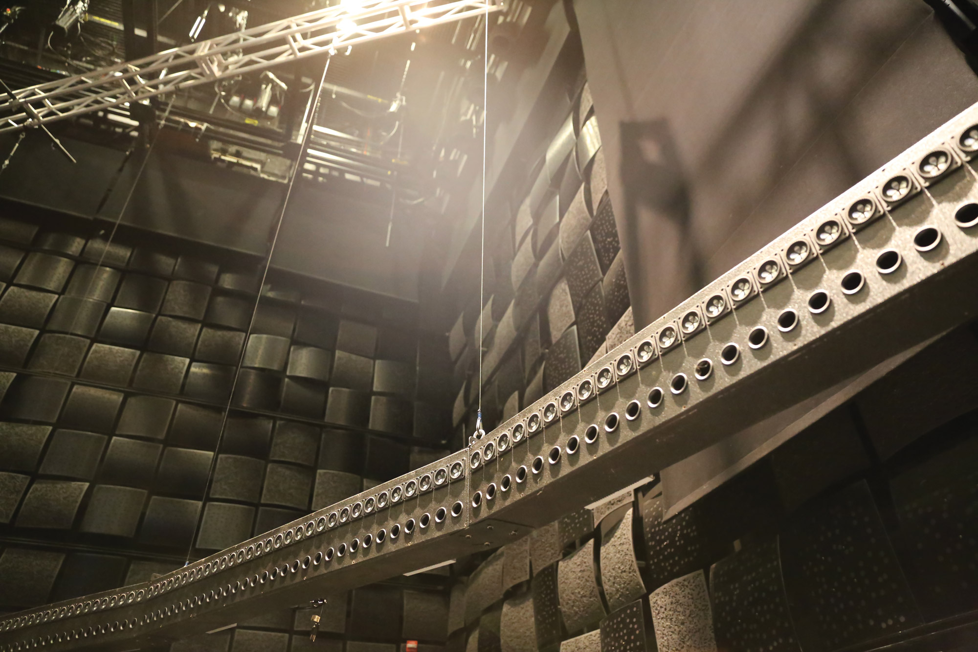 The wave field synthesis rig suspended from the ceiling of a black box studio. 