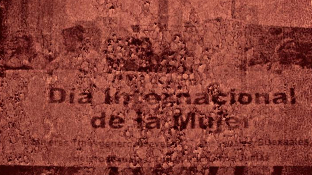 Burgundy text on a red wall reading Dia Intergnacional de la Mujer. 
