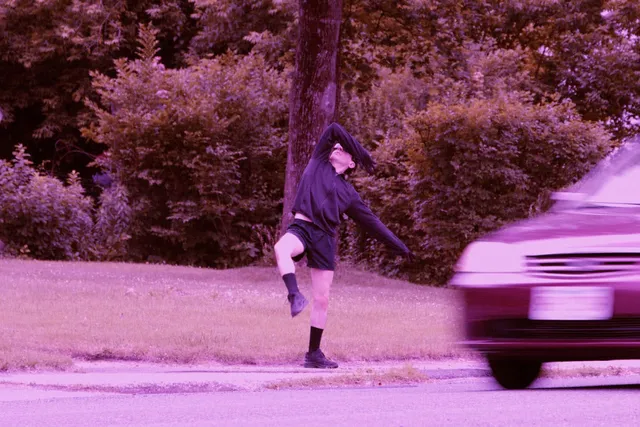 a man dancing on the side of a road