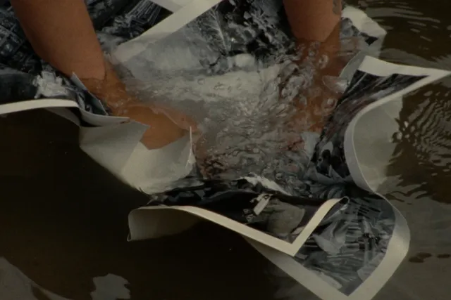 a person pushes photographs under water