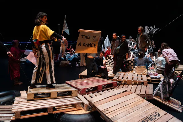 a group of people interacting with a structure made of wood pallets in a black box studio