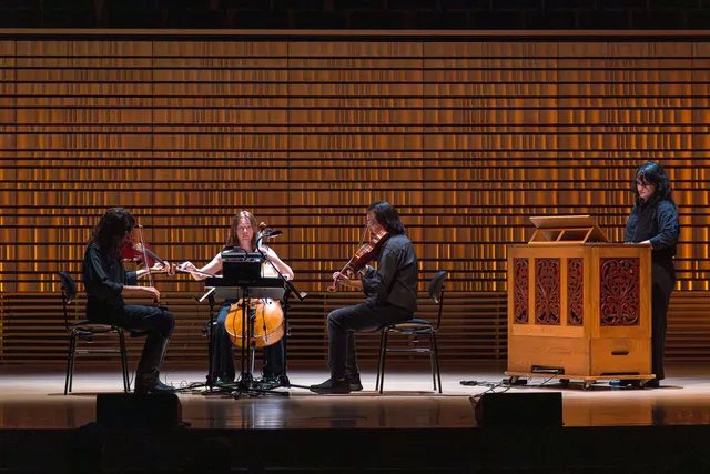 a quartet on a concert hall stage.