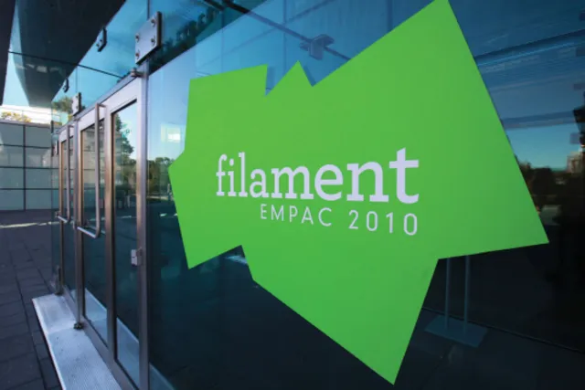 A lime green jagged shape on the outer windows of EMPAC, in white font reading "filament, EMPAC 2010" 