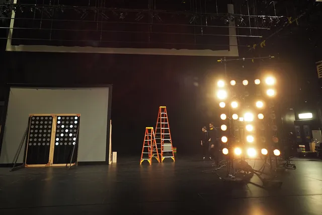 Behind the scenes of a  black box theater with various lighting in X and Y. 