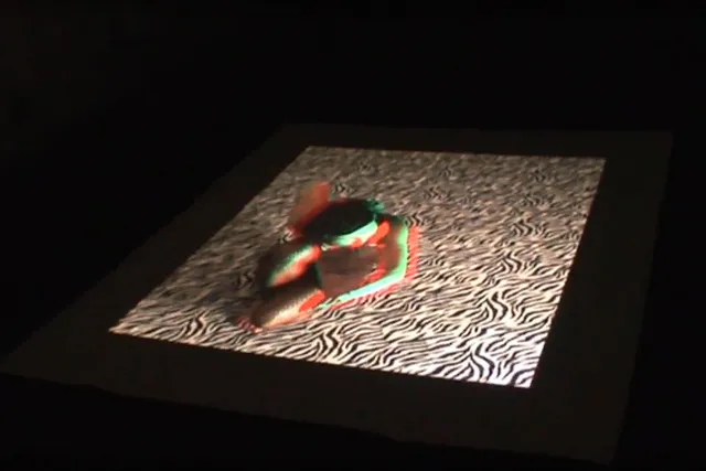 A dancer blurred with green and red shadow laying on their side on a zebra print floor. 