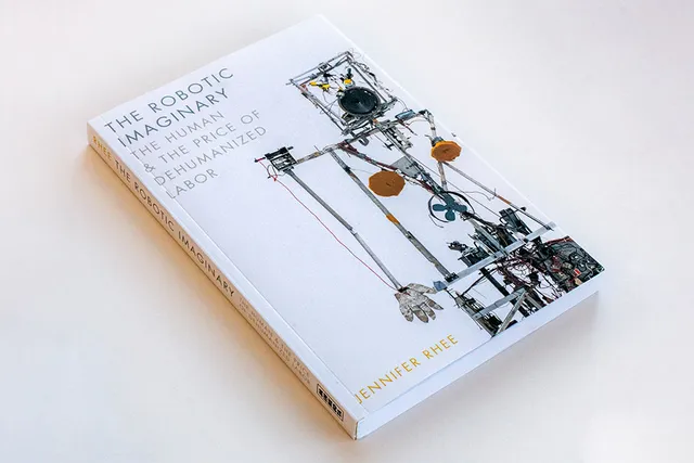 A white book with a robot type sculpture on the cover, The Robotic Imaginary: The Human and the Price of Dehumanized Labor, By Jennifer Rhee. 