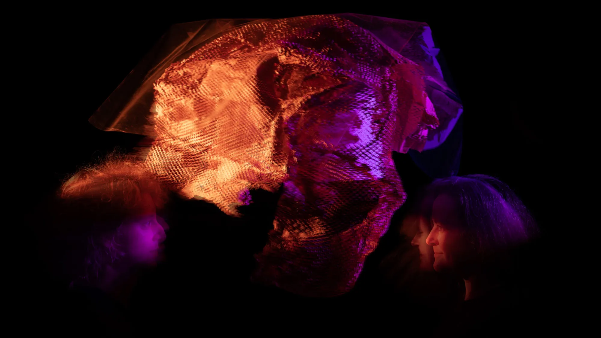 an abstract swirl of orange and purple light against a black background with the profile of a woman in the bottom right corner
