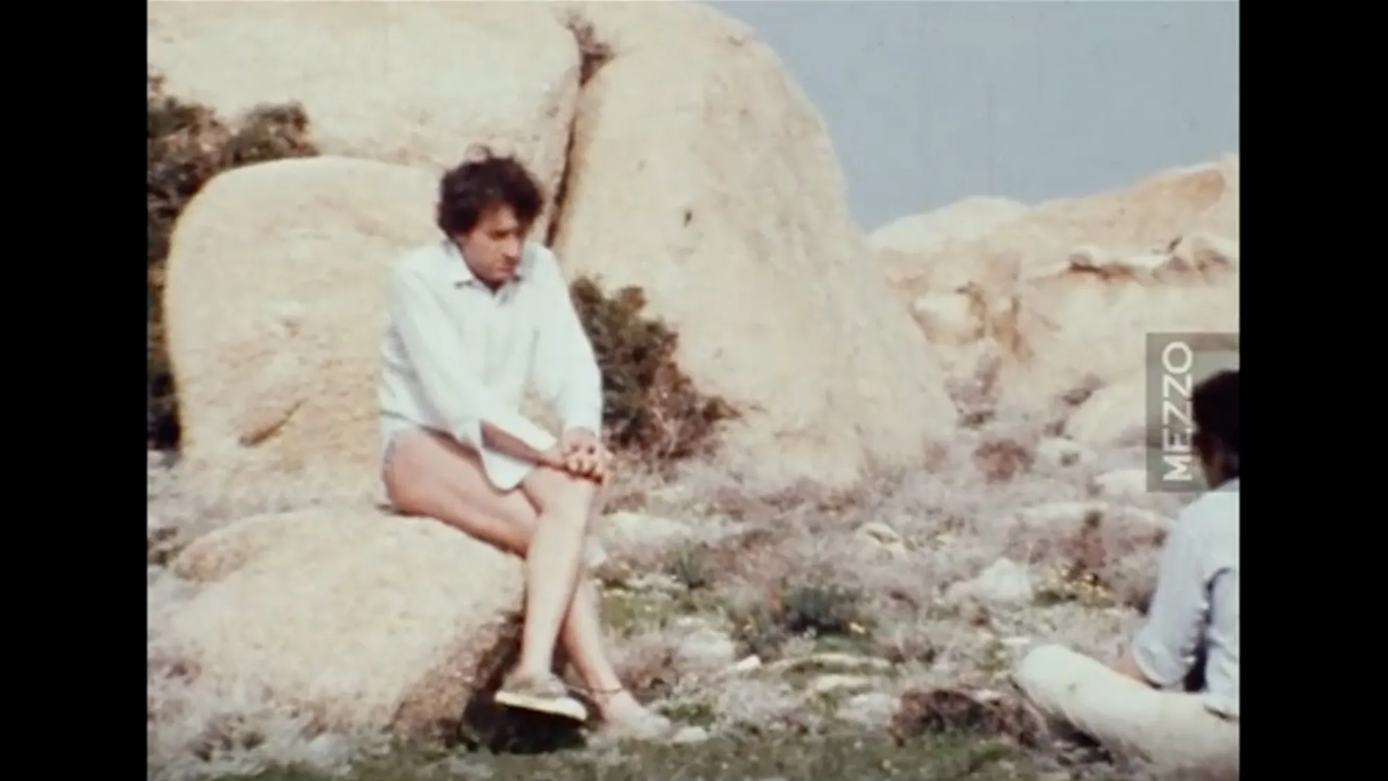 xenakis sitting on a rock in 1971 while being interviewed for the film.