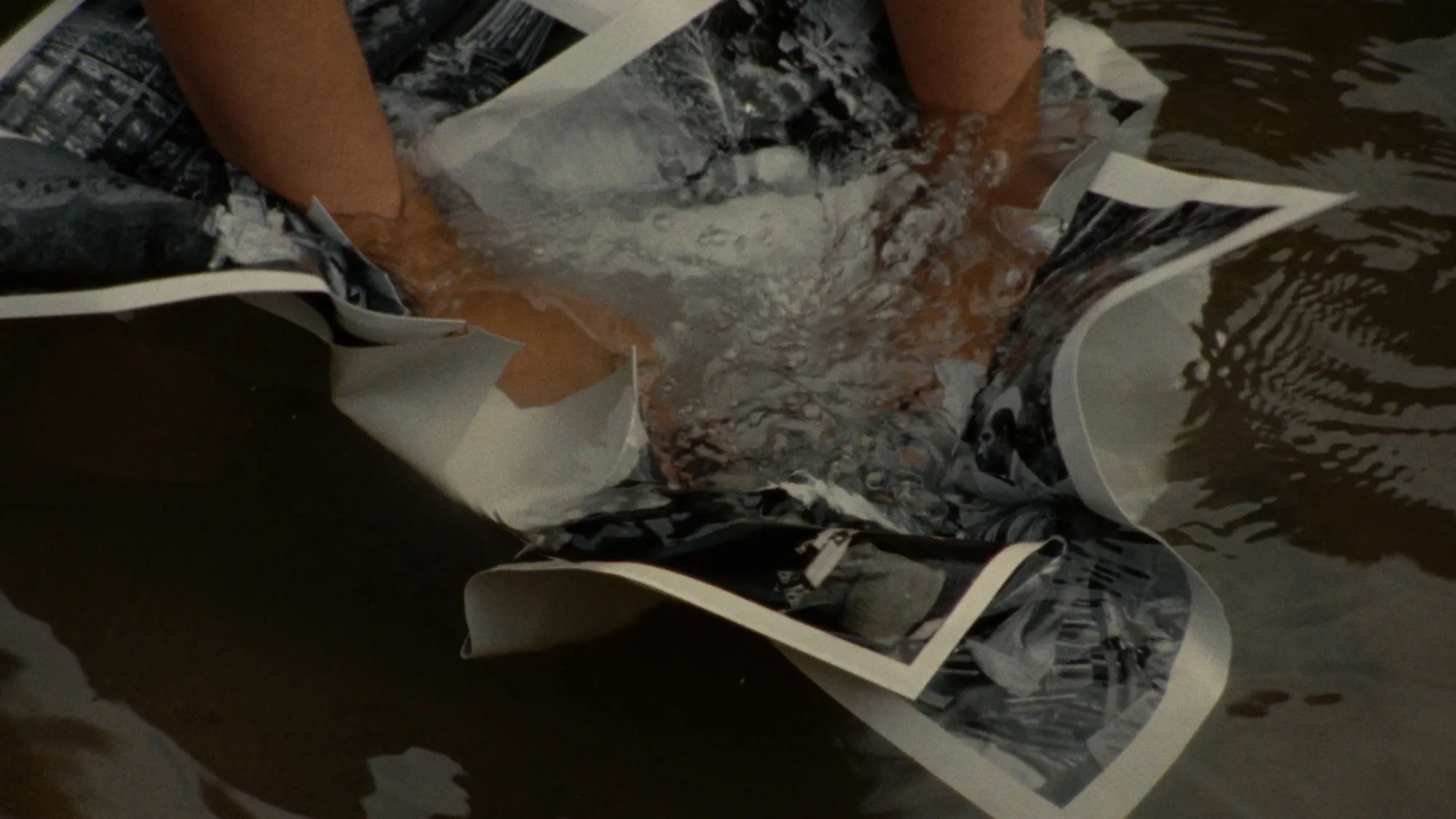 a person pushes photographs under water