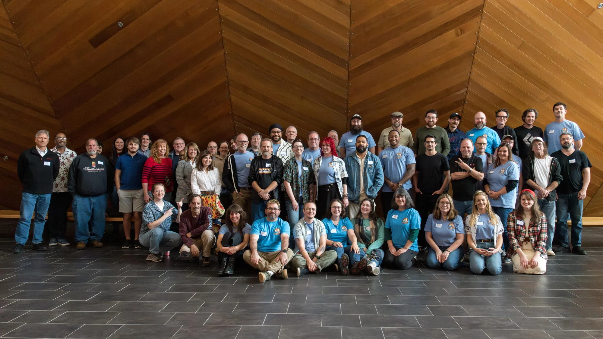 the entire EMPAC staff in front of a concert hall hull made of redwood