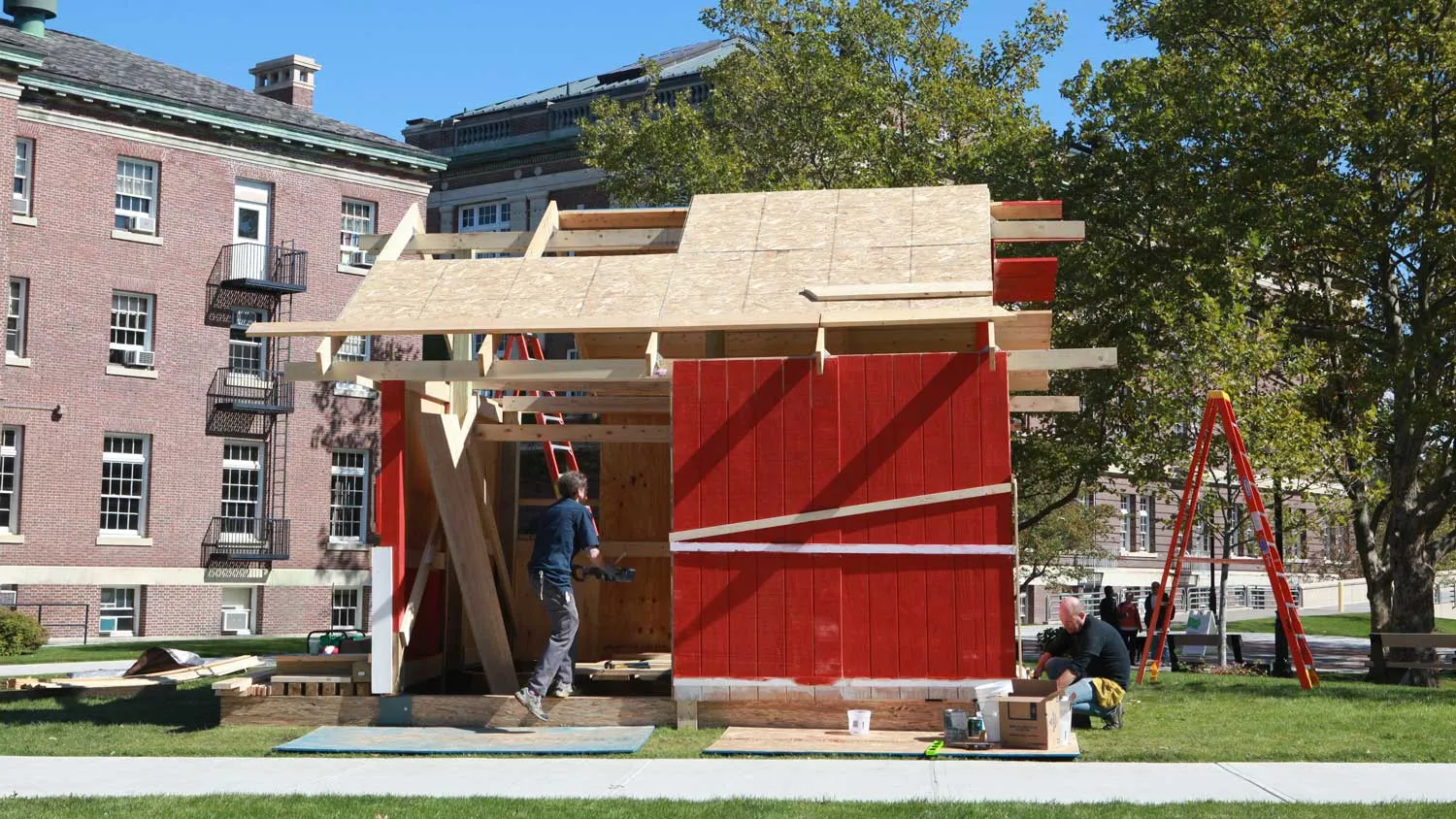 A red barn like structure in mid construction on the bustling RPI campus. 